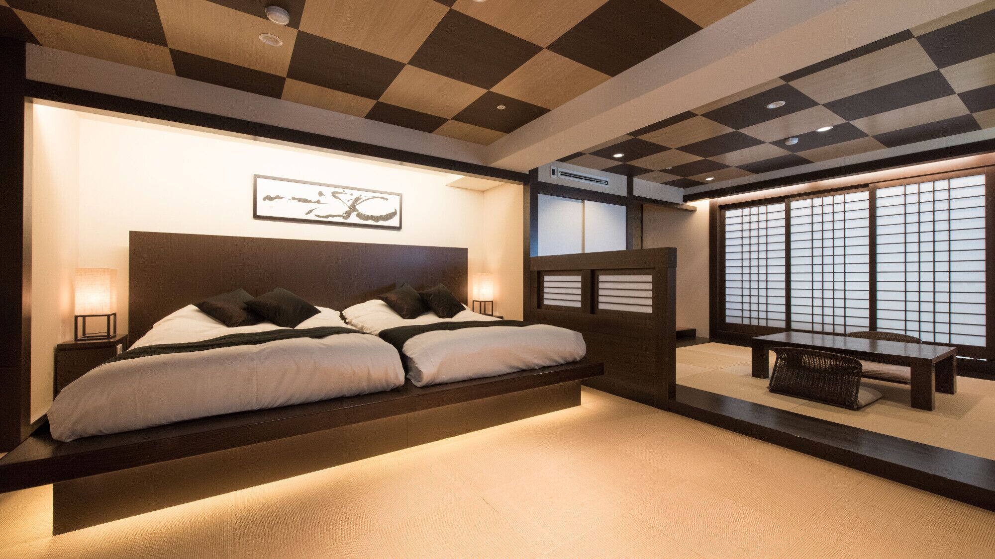 A modern hotel room with a large bed, bedside lamps, a wall-mounted air conditioner, and a view through a shoji screen.