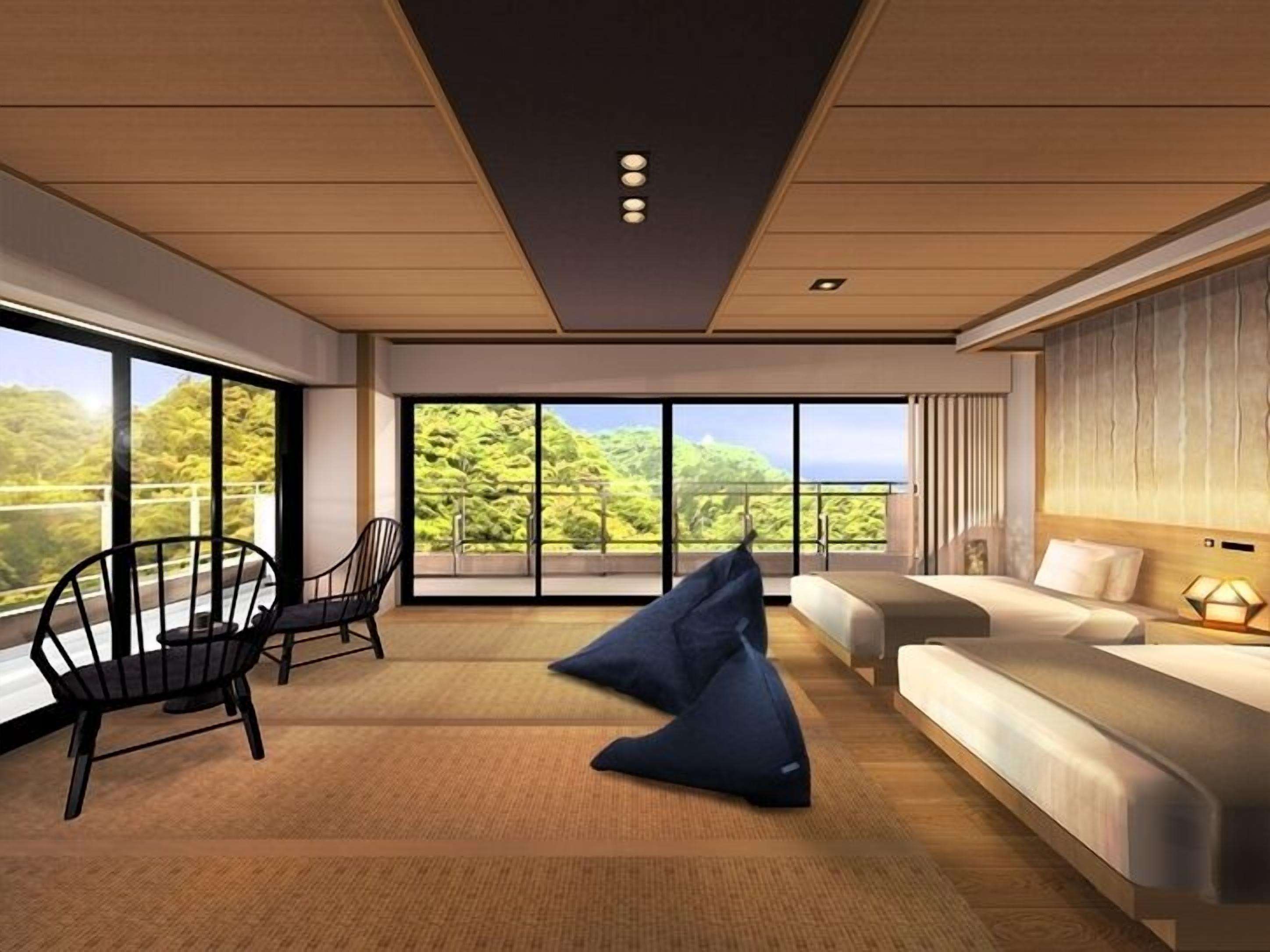 A modern hotel room with a large balcony, a sofa, a chair, and a bean bag.