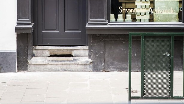 A storefront with a black door and window display. - La Maison Haute Guest House (Brussels)