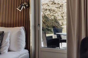 A room with a bed, a window, and an outdoor seating area with chairs. - BauerGården Gästgiveri & Konferens (Gränna)