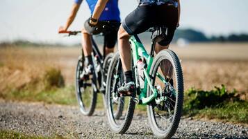 Two cyclists riding bicycles on a gravel path.