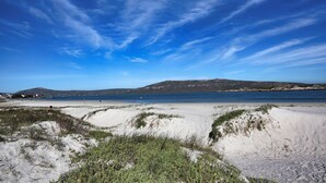 En strand med sanddyner och en klar, blå himmel.