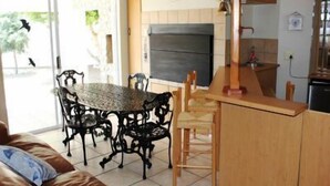 A compact kitchen with a dining area, a large window, and a view of the outdoors. - 6 Nendaz Self catering (Langebaan)