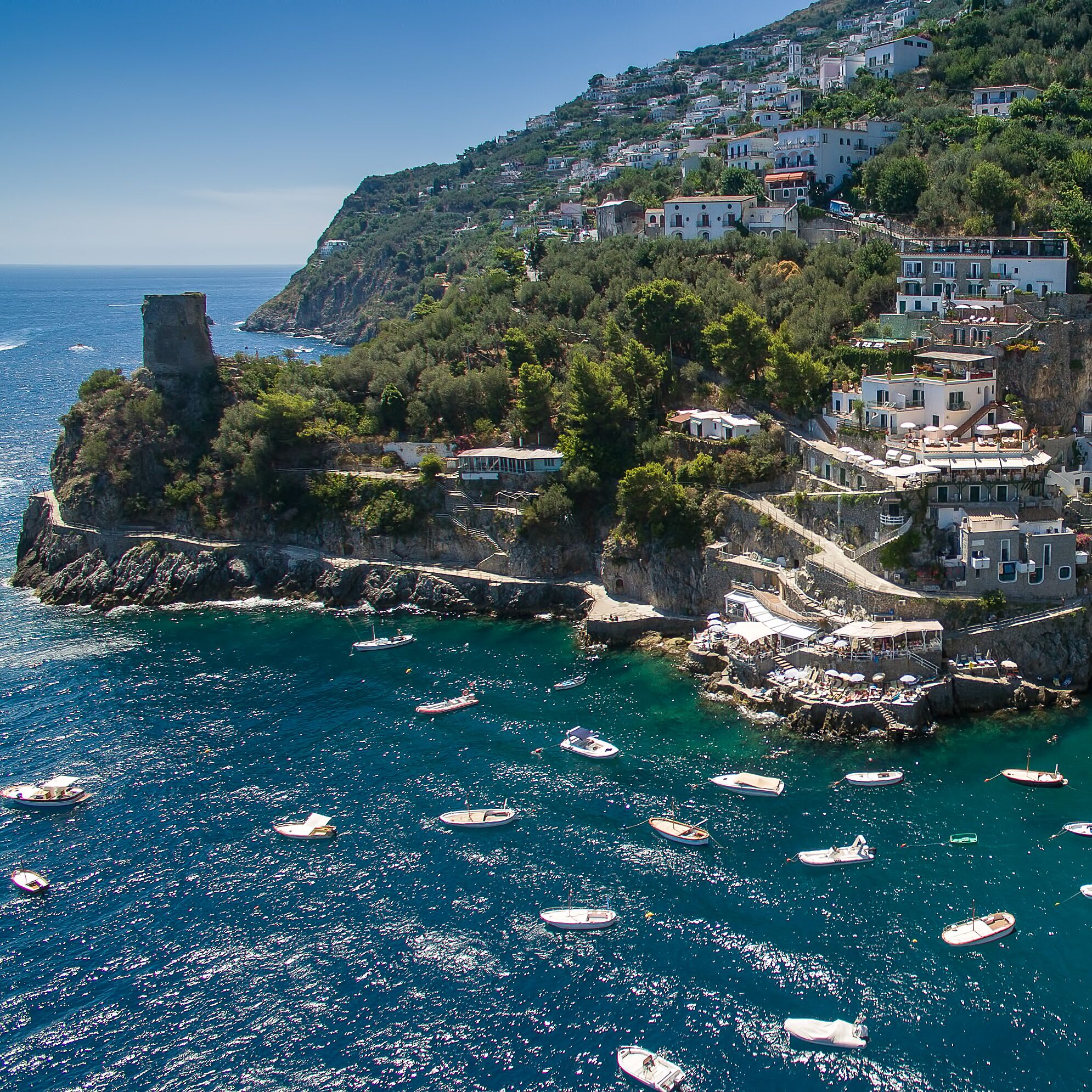 A coastal town with buildings on a hillside overlooking the sea.