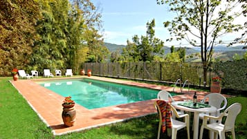 En säsongsöppen utomhuspool, parasoller och solstolar