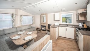 Une cuisine compacte pour camping-car, comprenant un coin repas, un four encastré et un évier.