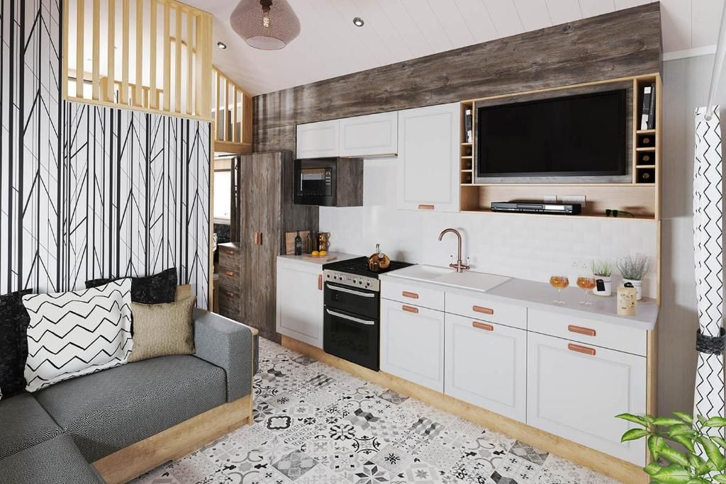 Una cocina moderna con armarios blancos, horno empotrado y un televisor de pantalla plana grande.
