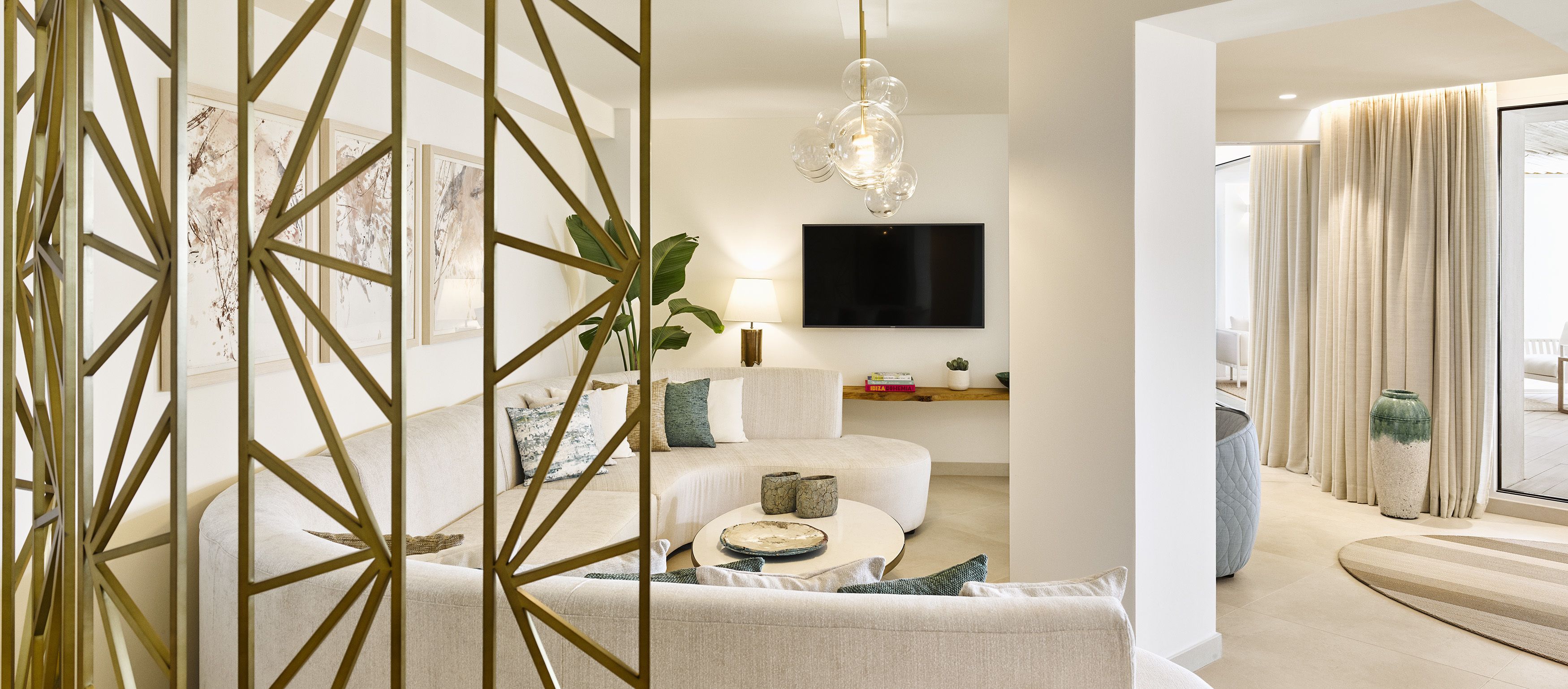 Una sala de estar moderna con un sofá, una mesa de centro y un televisor montado en la pared.