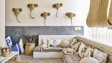 A cozy living room with a sofa, decorative wall art, and a window with natural light.