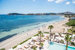 En la playa, playa de arena blanca, camastros y sombrillas