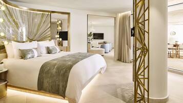Een moderne hotelkamer met een groot bed, nachtkastjes, een spiegel en uitzicht op de ontbijtruimte.