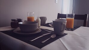 A breakfast setup with a bowl, mug, and glasses of orange juice on a table with a keyboard and utensils. - The Red Cottage & Stables (Sligo)