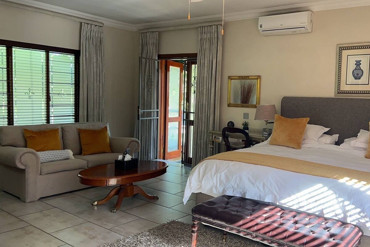 Una habitación de hotel con una cama, un sofá, un escritorio y una silla.