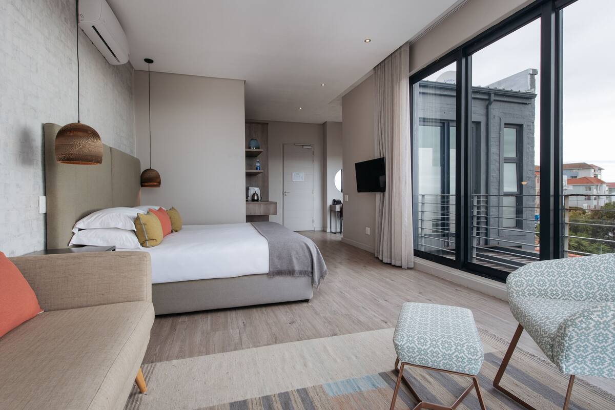 Een moderne hotelkamer met een groot bed, een bank, een kleine tafel en een televisie.
