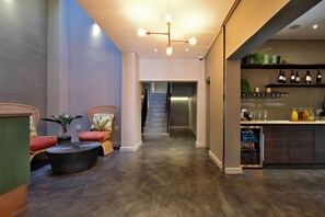 A modern interior with a seating area, a staircase, and a bar with wine bottles.