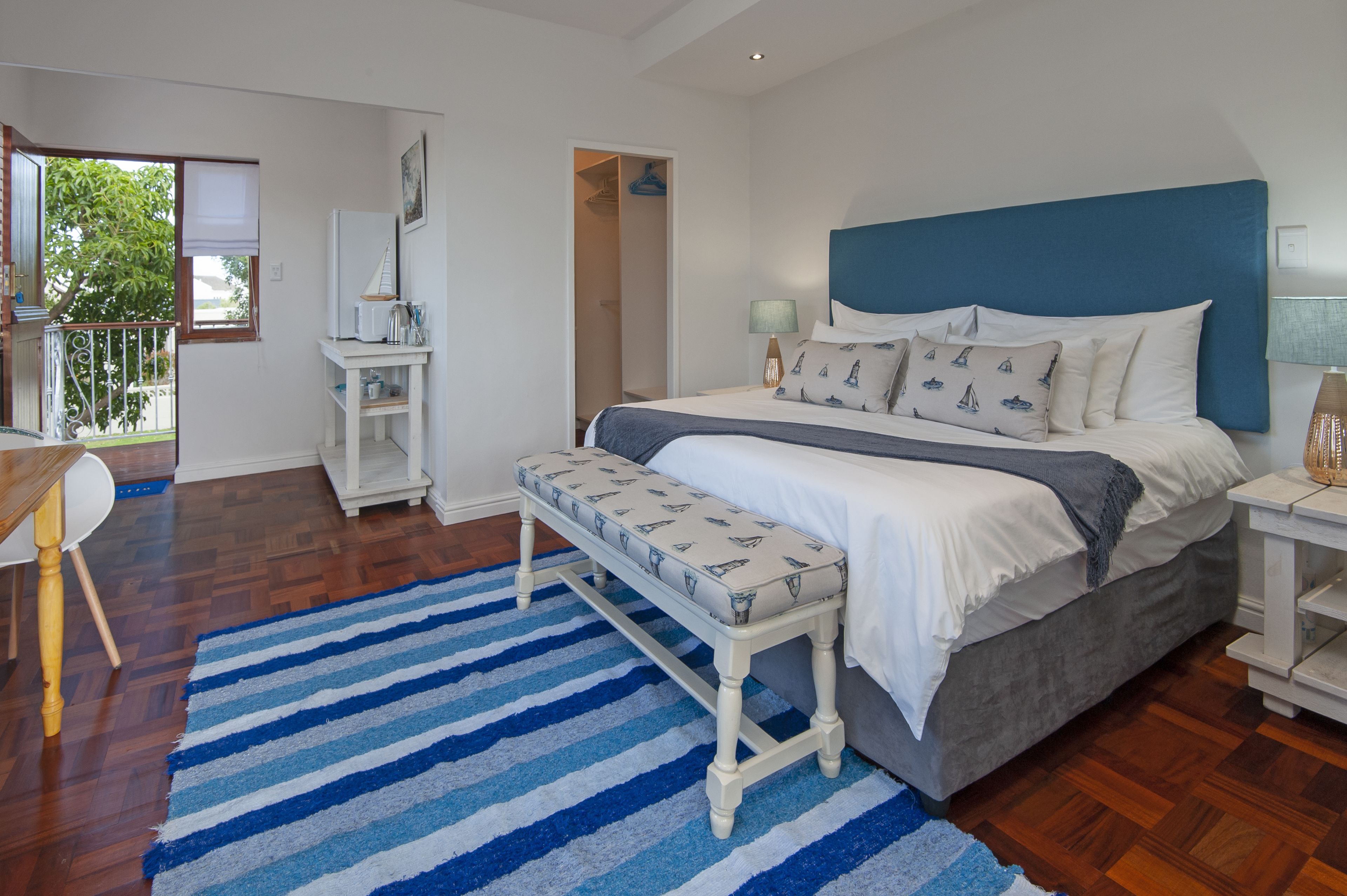 Un dormitorio con una cama grande, un banco, un escritorio y una silla.