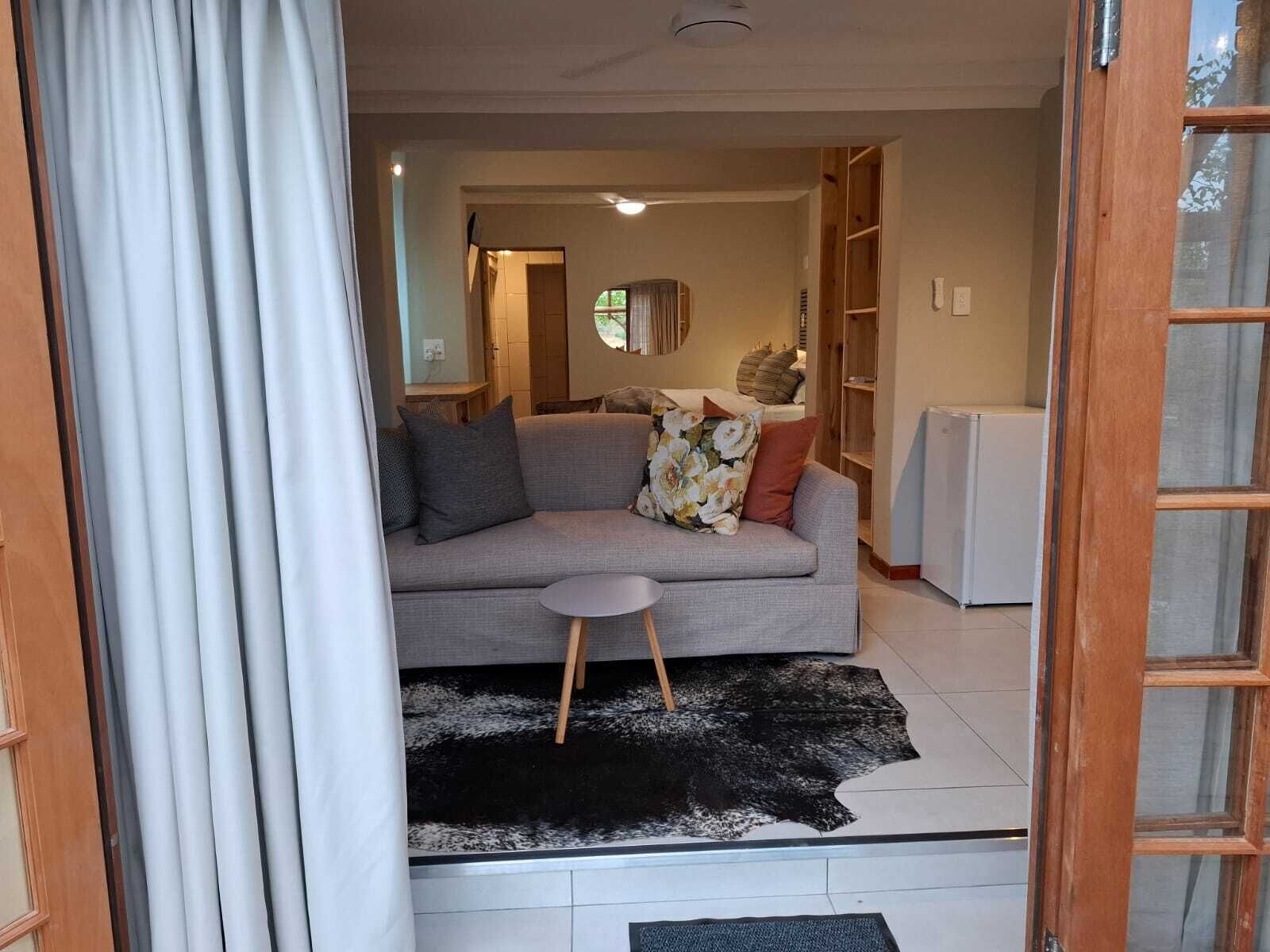 Una sala de estar con un sofá gris, una mesita redonda y un tapete blanco y negro.