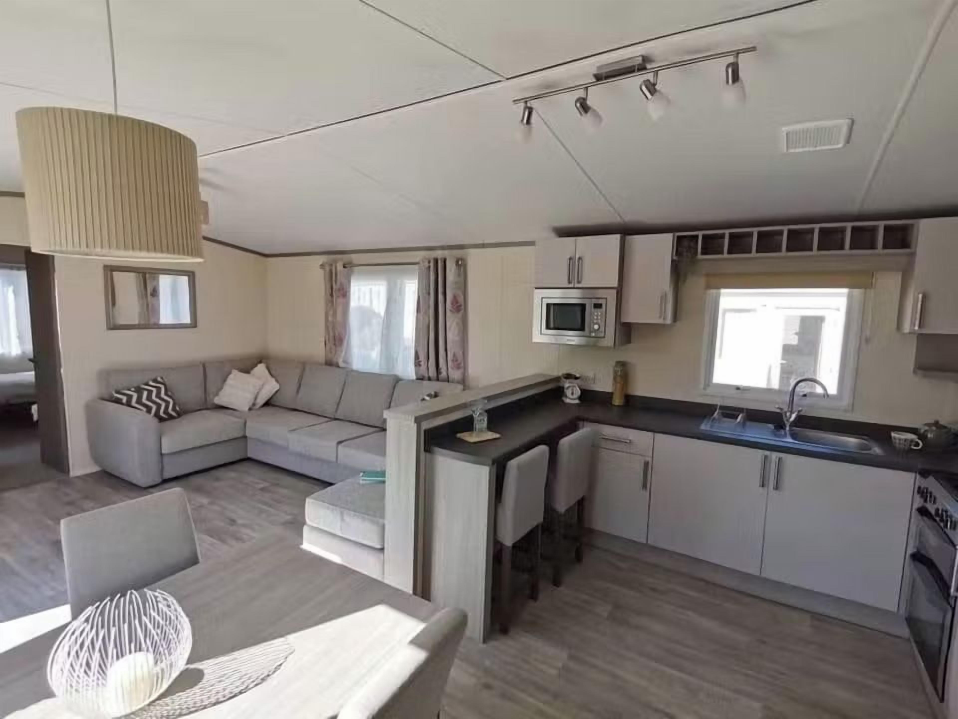 A modern kitchen with a microwave, sink, and cabinets.