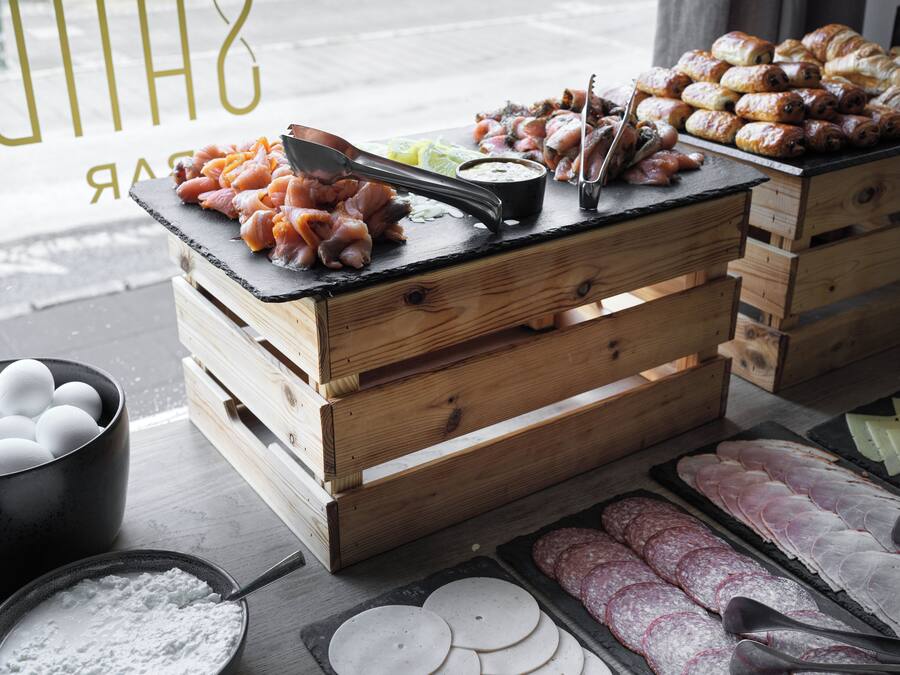 A food display with various meats and pastries on wooden crates.