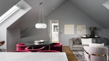 Un loft moderno con comedor, sala de estar y una escalera que lleva a un nivel superior.