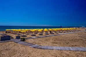 En la playa, camastros, sombrillas y windsurf 