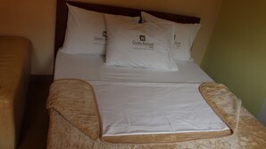 Una habitación de hotel con cama, almohadas y manta.