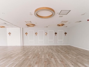 Ein geräumiges Zimmer mit Holzdielen, Deckeneinbauspots und einer weißen Tür.
