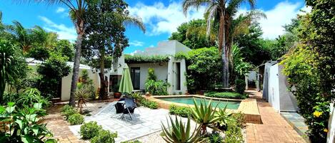 Een buitenzwembad, parasols voor strand/zwembad