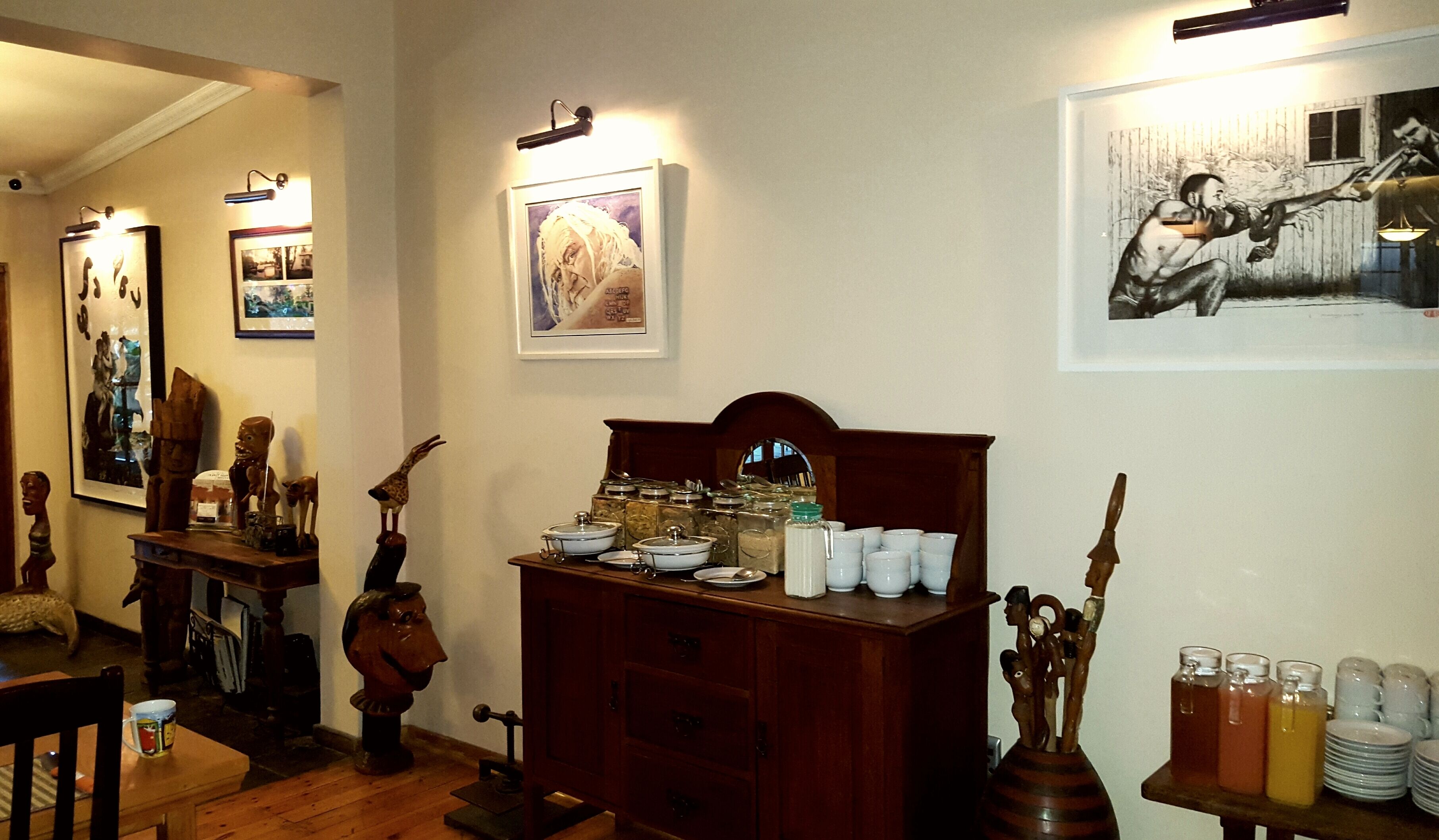 A room with a wooden cabinet, a dining table, and various decorative items.
