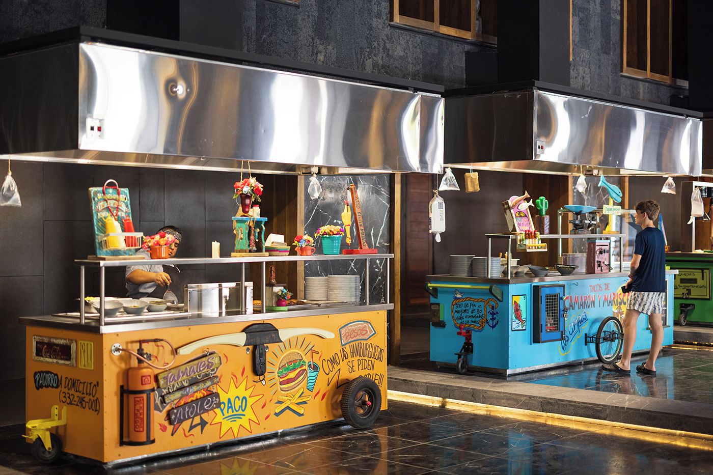 A food cart with a colorful design and a sign that reads "PACARO DOMICILIO".