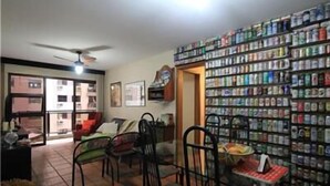 A room with a dining area, chairs, a table with food, and a wall of canned goods. - GoHouse Dulcidio 307 (Rio de Janeiro)