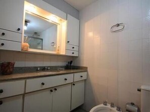 A bathroom with a white sink, mirror, and toilet. - GoHouse Dulcidio 307 (Rio de Janeiro)