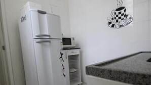 A kitchen with a white refrigerator, a microwave, and a small countertop. - GoHouse Copacabana 901 (Rio de Janeiro)