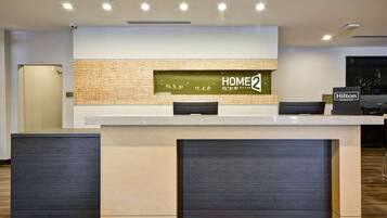 Una taquilla moderna amb un senyal que diu "HOME2", una pantalla digital i una placa de "Hilton Honors".