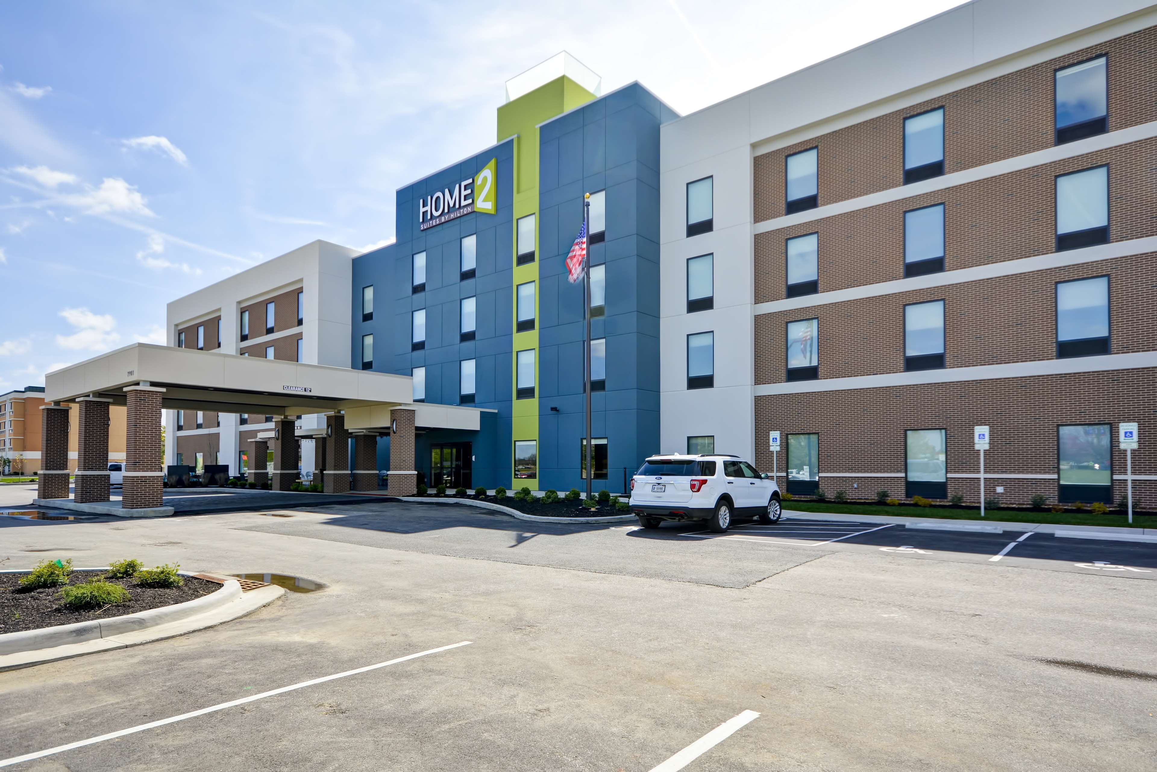 A multi-story hotel with a modern design, featuring a prominent 'HOME 2' sign.