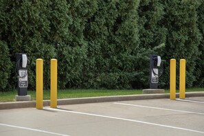 A parking area with electric vehicle charging stations, marked for guest use, and a Hilton hotel sign. - Hampton Inn Decatur Mt. Zion (Decatur)