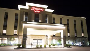 A Hampton Inn hotel with a well-lit entrance, a parking lot, and a car parked outside. - Hampton Inn Decatur Mt. Zion (Decatur)