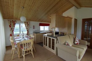 A cozy interior with a dining area, kitchen, and seating space. - Killigarth Manor Holiday Park (Looe)