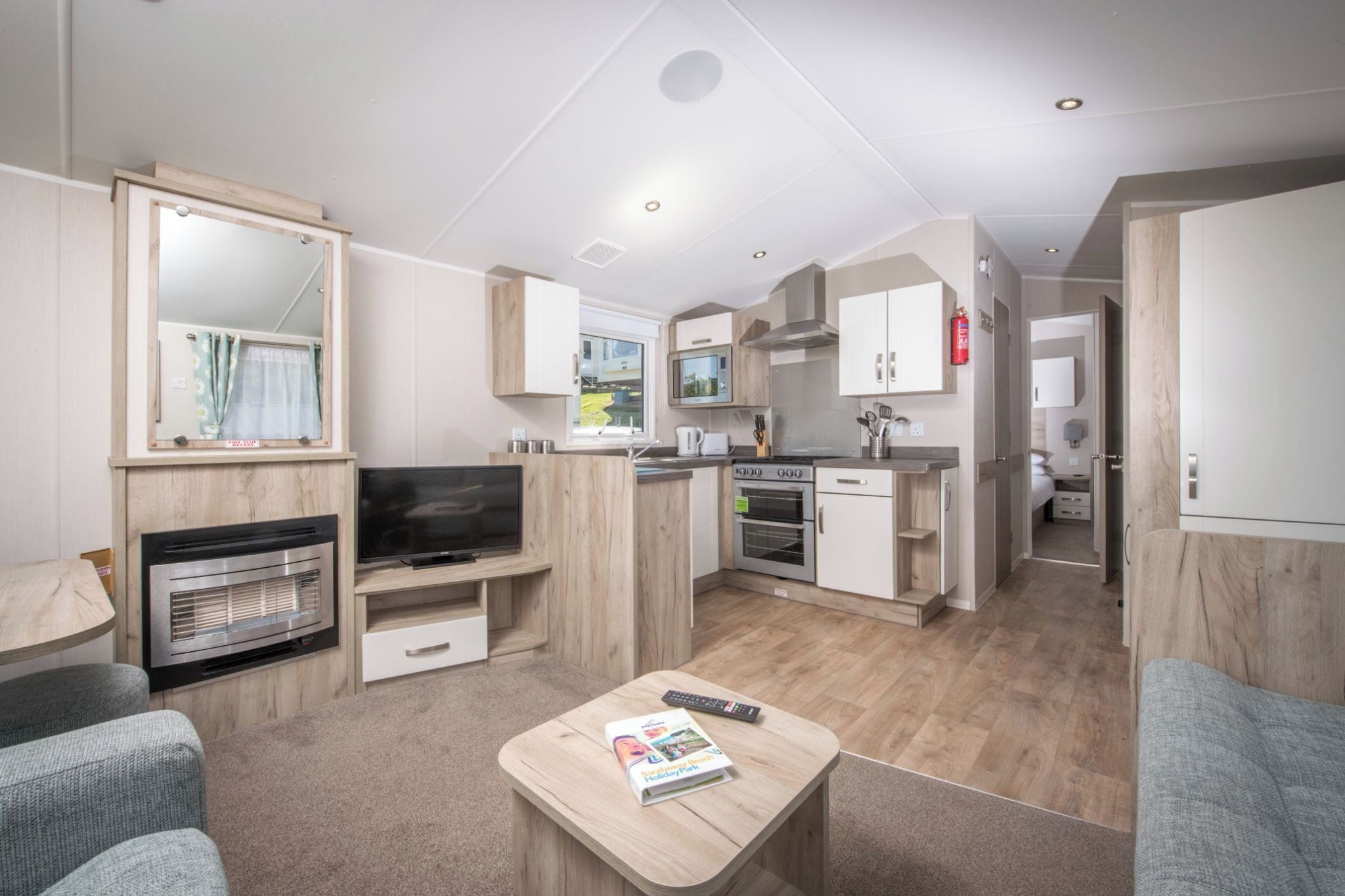 A compact living space with a kitchenette, a television, a fireplace, and a dining area.