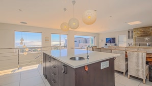 A modern kitchen with a large island, stainless steel sink, and overhead pendant lighting. - Seasons of Serenity, Langebaan 8-sleeper (Langebaan)