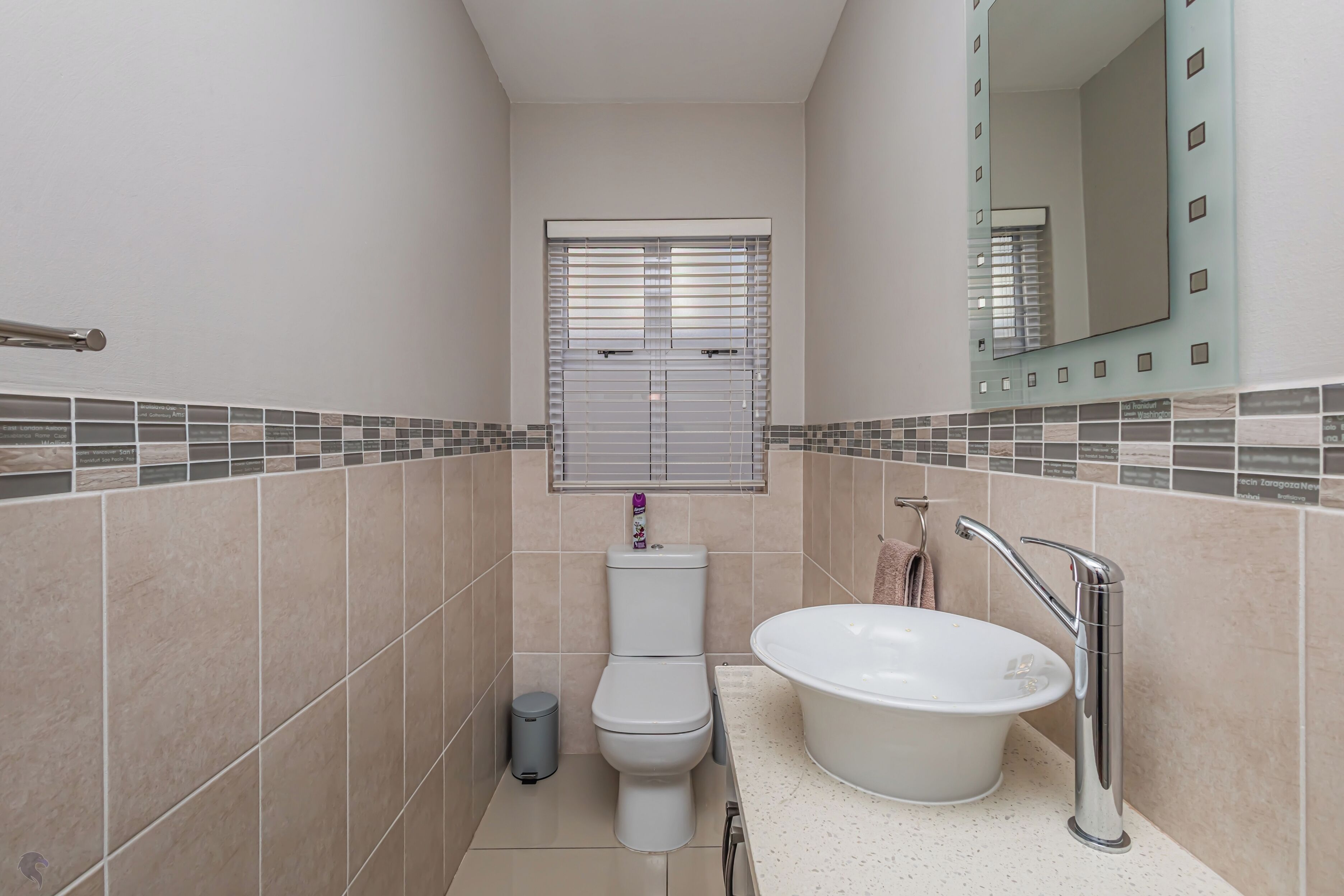 Un baño con inodoro, lavamanos y ventana con persianas.