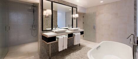 A modern bathroom with a large bathtub, a walk-in shower, and a double sink vanity.