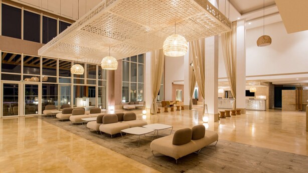 A spacious lobby with modern seating, large windows, and decorative ceiling panels. - Radisson Blu Resort, Saidia Beach (Saidia)