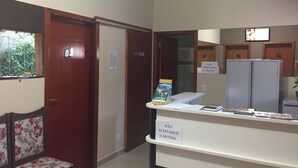 Zona de recepción con escritorio, sillas y refrigerador. Se indica que no se aceptan tarjetas.