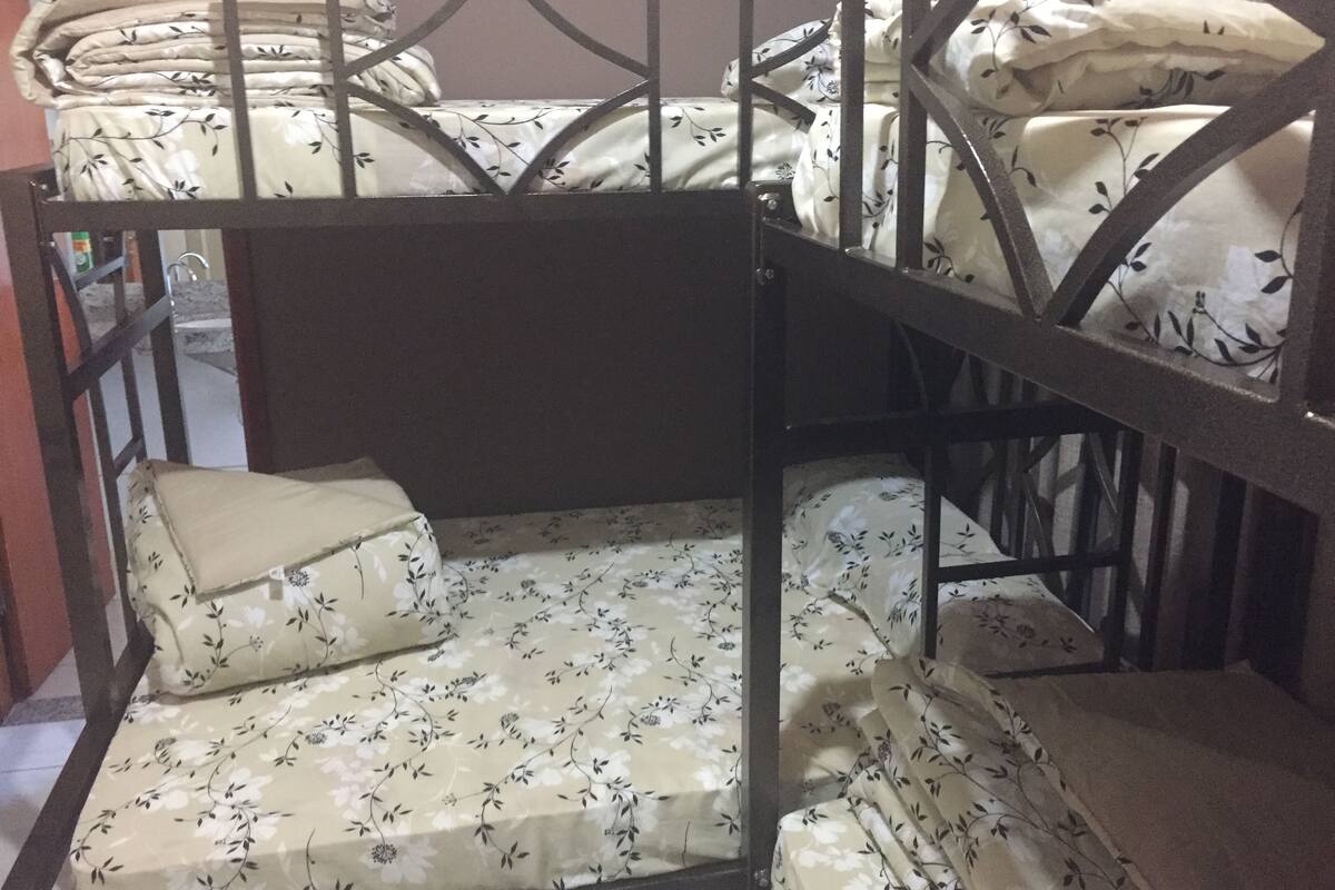 Una cama litera con ropa de cama floral y estructura metálica.