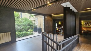 Un interno moderno con una scala, un'area pranzo e vista su del verde all'esterno.