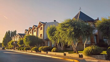 Una hilera de edificios modernos de dos pisos con un estilo arquitectónico uniforme, que cuenta con grandes ventanales y un techo plano.
