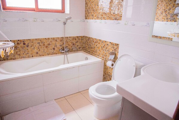 Ein Badezimmer mit Badewanne, Toilette und Waschbecken.