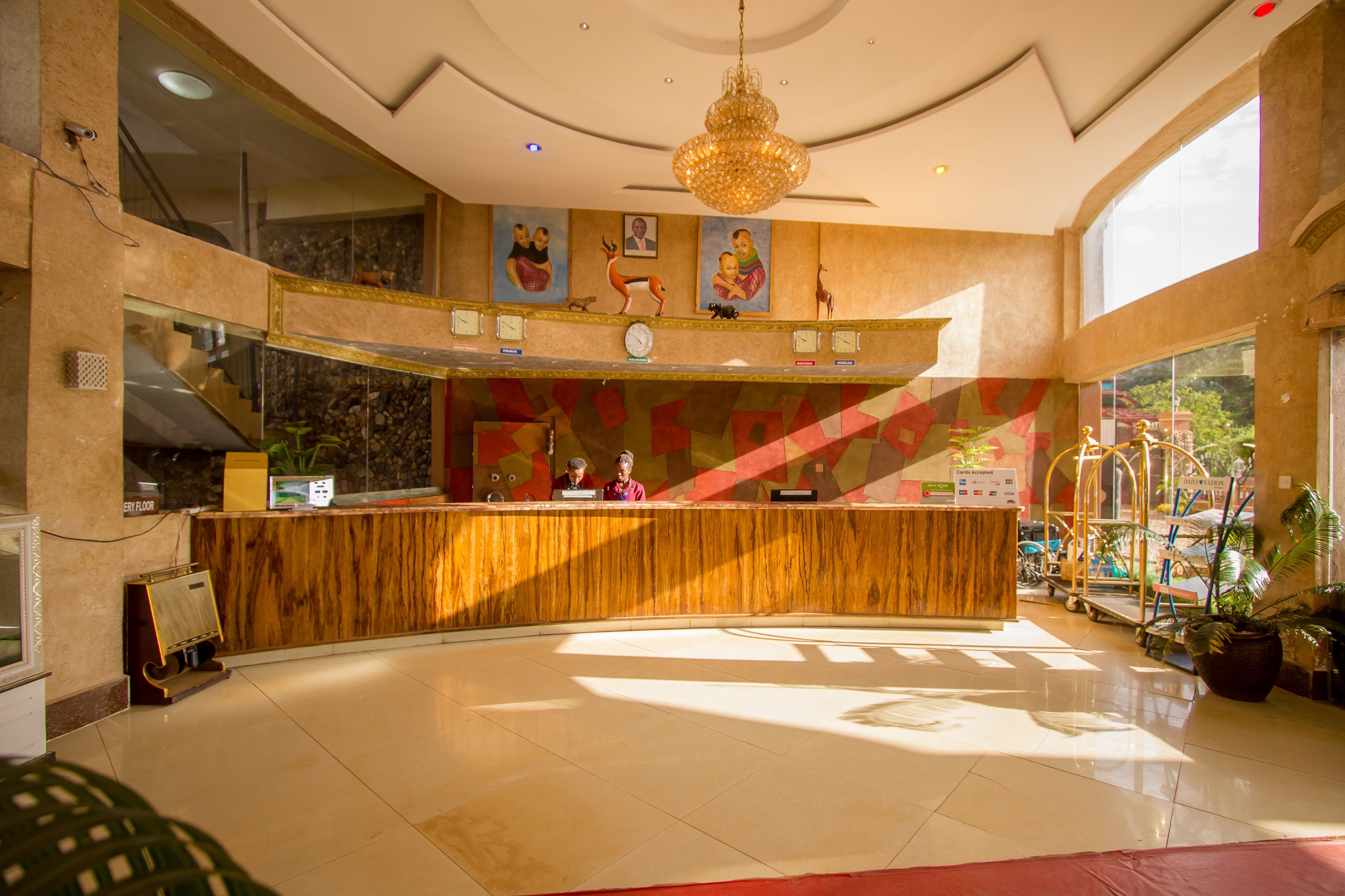 A reception area with a marble counter, a chandelier, and artwork on the walls.