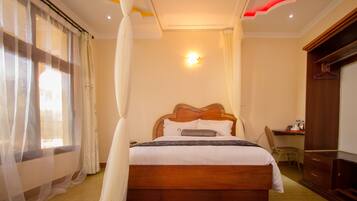 A bedroom with a wooden bed, a desk, and a wardrobe.